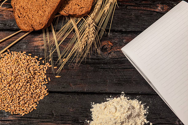 istock Spikelets of wheat and rye bread on a wooden table 519165108