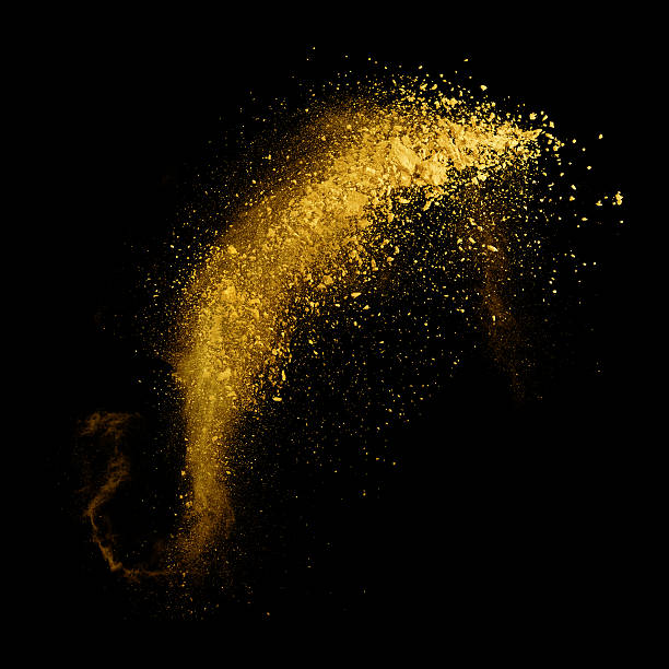 istock Explosion of yellow powder on black background 519165662