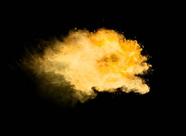 istock Explosion of yellow powder on black background 519165714