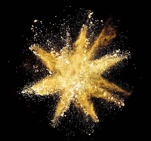 istock Explosion of yellow powder on black background 519165832