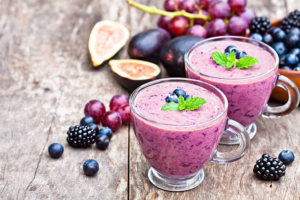 fresh  healthy pulpy cocktail with purple fruits and berries