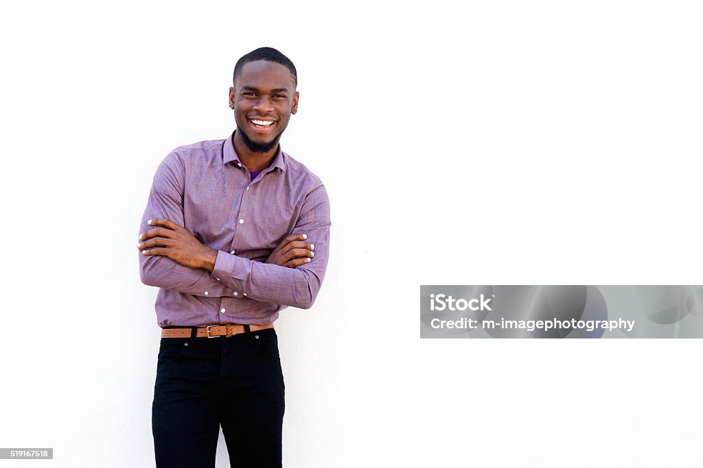 Happy young african guy with his arms crossed Portrait of happy young african guy with his arms crossed while standing against white background Men Stock Photo