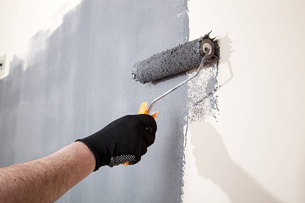 istock Renovation of interior. Hand holds paint roller and painting wall 519167778