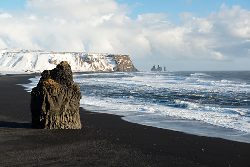 Winter landscape with Reynisdrangar stacks, mountain, black sand beach, Iceland