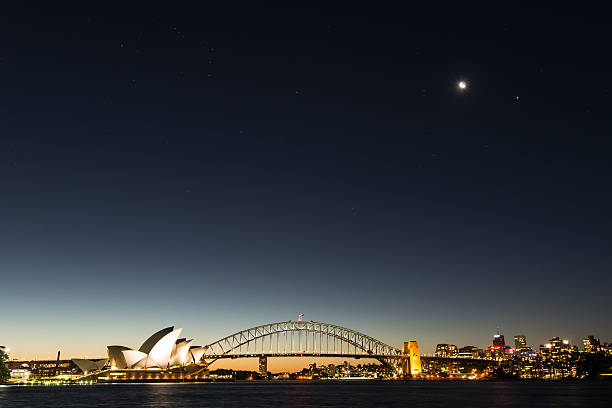 сиднейский оперный театр и гавань сиднея, моста в сумерках - the rocks sydney harbor sydney australia new south wales стоковые фото и изображения