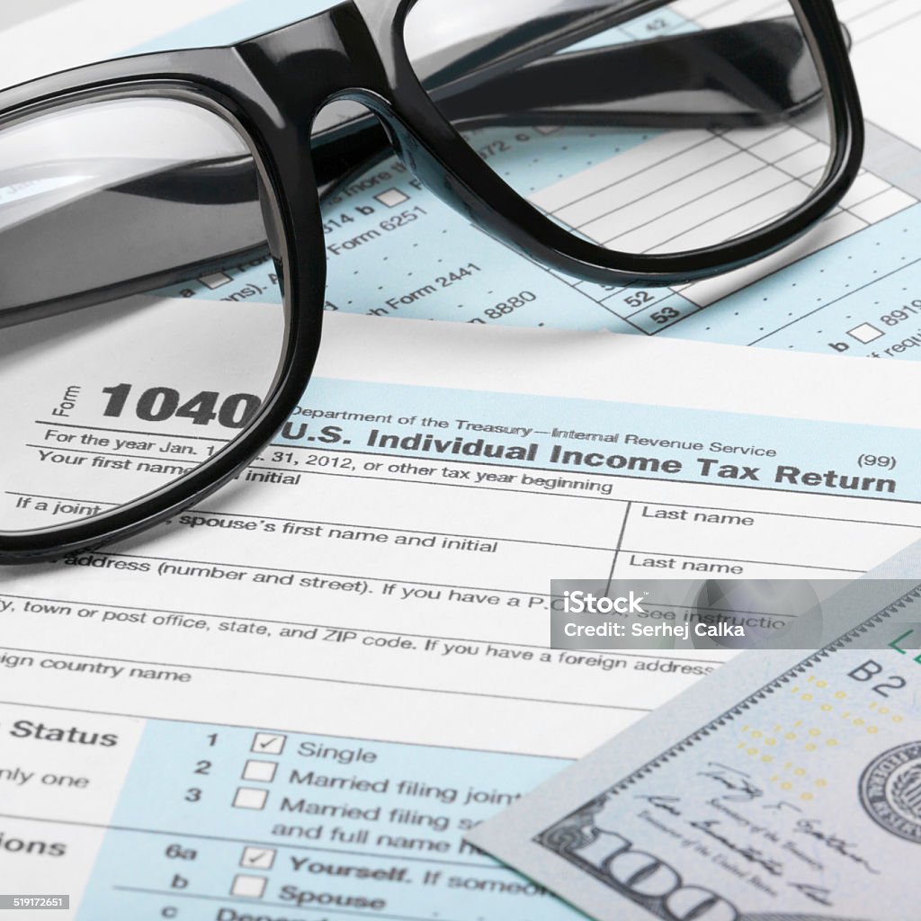 Tax Form, dollars and glasses - 1 to 1 ratio US Tax Form 1040 with dollars and glasses - 1 to 1 ratio 1040 Tax Form Stock Photo