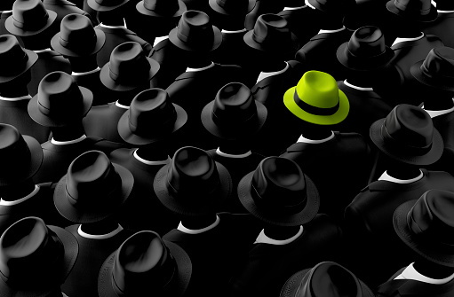 Different, leader, best, unique, boss, individuality, original, special, worst, first, chief, champion and discrimination concept. Yellow Green Fedora Hat Surrounded by Black Hats on Mannequins. Emphasizing Unique, Special and Stand out in the Crowd. Can be Used for Background Design.