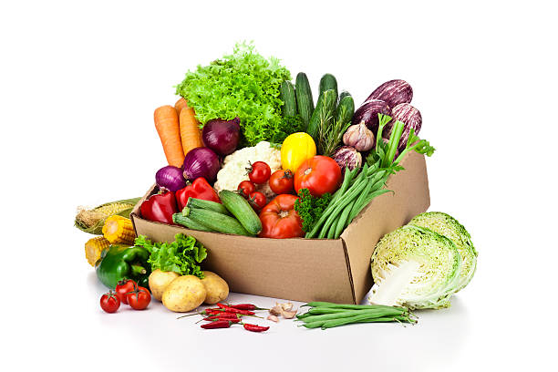 Crate filled with assortment of organic vegetables on white backdrop