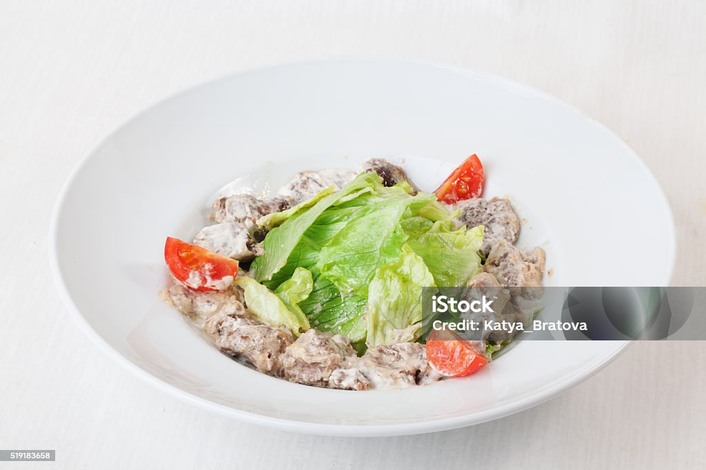 salad with meat in a creamy sauce, ase, lettuce, romaine, salad with meat in a creamy sauce, ase, lettuce, romaine, iceberg cherry tomatoes on top of the plate isolated white background series menu Beef Stock Photo