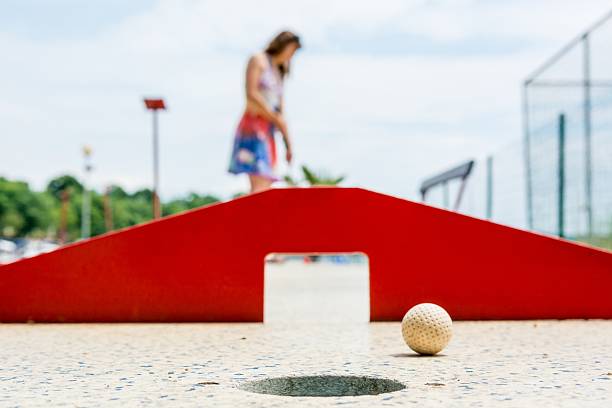 Attractive young woman playing mini golf. stock photo