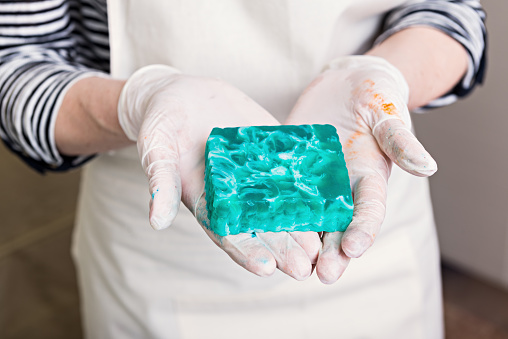 Woman is holding handmade soap just after preparation
