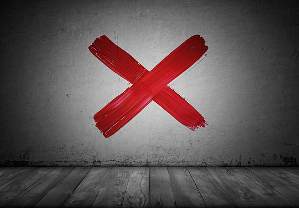 Red paint brush texture watercolor cross mark on a concrete wall background. Stop symbol.