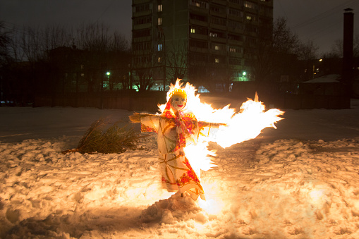 Shrovetide scarecrow burnes at night in the snow