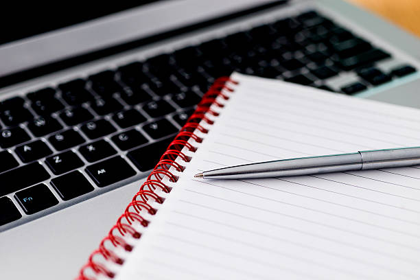 istock Laptop with pen and spiral notebook 519188106