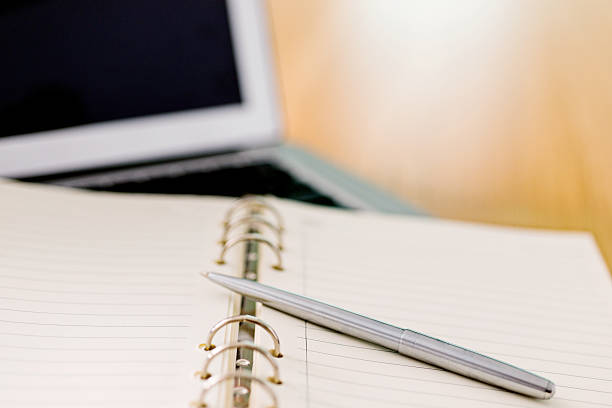 istock Laptop with pen and spiral notebook 519188642