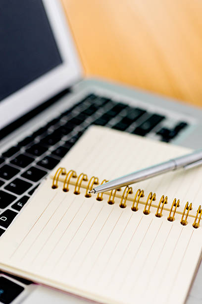 istock Laptop with pen and spiral notebook 519188760