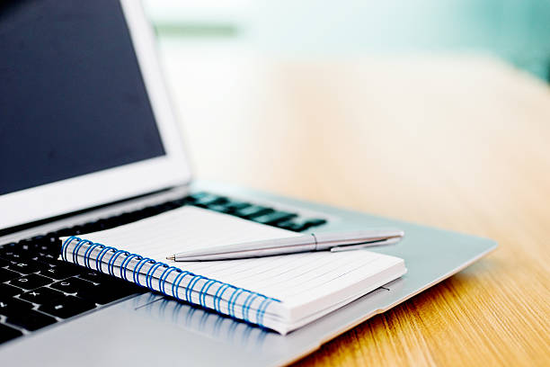 ordenador portátil con una pluma y cuaderno con espiral - desk corporate business business paper fotografías e imágenes de stock