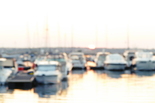 Silhouettes of yachts on a quay at sunset. Reflection on the water.