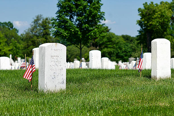 Rows of Tombstones, Low Angle, Arlington National Cemetery Arlington, Virginia, USA - May 24, 2015: Rows of tombstones with small American flags at Arlington National Cemetery at Fort Myer, Virginia. arlington cemetery in spring stock pictures, royalty-free photos & images