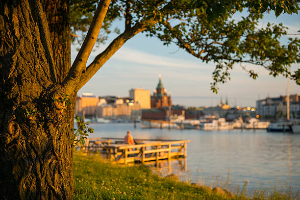 A summer evening view at Tervasaari (Tar Island), a park in Helsinki, Finland. The red building across the harbor is Uspenski Cathedral, an Orthodox church.