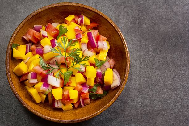 istock Homemade Mango salsa served in a wooden plate top view 519196310