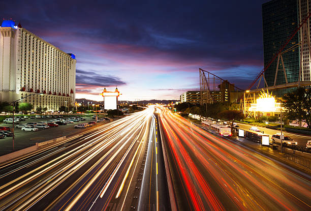 busy traffic on road and modern buildings in purple sky busy traffic on road and modern buildings in purple sky in las vegas nevada highway stock pictures, royalty-free photos & images