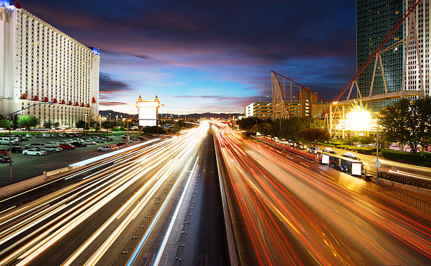 busy traffic on road and modern buildings in purple sky busy traffic on road and modern buildings in purple sky in las vegas nevada highway stock pictures, royalty-free photos & images