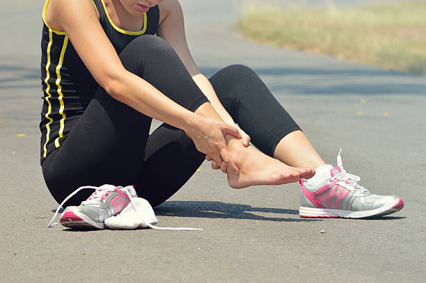 Young woman suffering from an ankle injury while exercising and Young woman suffering from an ankle injury while exercising and running hamstring injury stock pictures, royalty-free photos & images