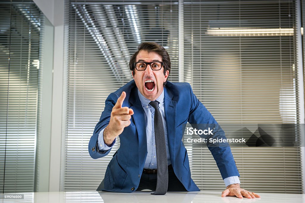 Angry Nerdy Boss Yelling Nerdy caucasian mid thirties businessman in glasses yelling. Manager Stock Photo