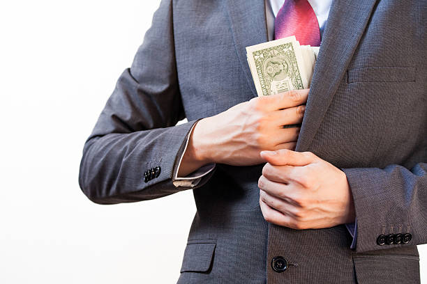 biznes człowiek ukrywanie pieniądze w kieszeni kurtki - embezzlement white collar crime stealing currency zdjęcia i obrazy z banku zdjęć