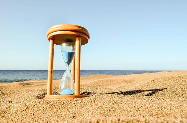 istock Hourglass Clock on the Sand Beach 519216930