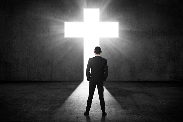 istock Business man looking the shining cross on the wall 519219354