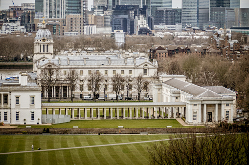 In the foreground is the Old Royal Naval College at Greenwich designed by Sir Christopher Wren. On the far side of the River Thames is the Canary Wharf business district.