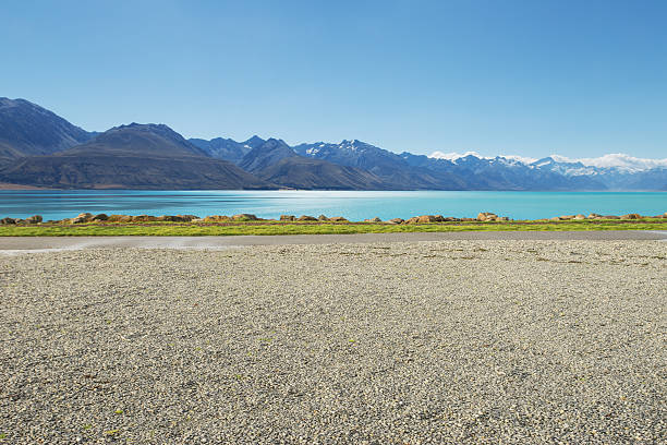 empty rural road near lake and snow mountain empty rural road near lake and snow mountain in new zealand gravel photos stock pictures, royalty-free photos & images