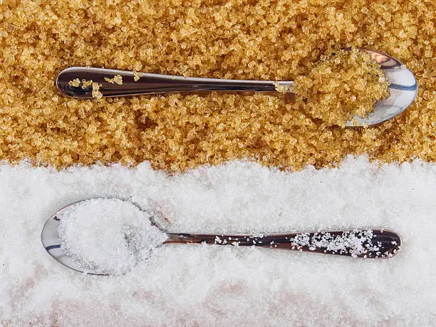 Spoon on white sugar and brown sugar