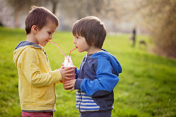 niedlichen jungen im park holding flasche mit smoothie, trinken - child portrait fine art portrait multi colored stock-fotos und bilder