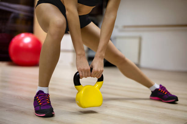 istock Unrecognizable female athlete exercising with kettle bell in a gym. 519226034
