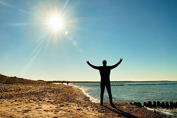 istock Tall man in suit exercising on stony beach at breakwater. 519226224
