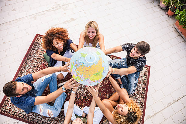 amigos segurando e olhando um globo terrestre - adolescence teenager globe map - fotografias e filmes do acervo