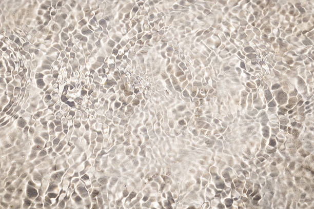istock Shining clear water ripple sandy beach background. 519227264