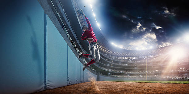 Baseball home run catch Outfielder baseball player about to perform a home run catch during baseball game on outdoor baseball stadium under dramatic stormy skies. baseball player photos stock pictures, royalty-free photos & images