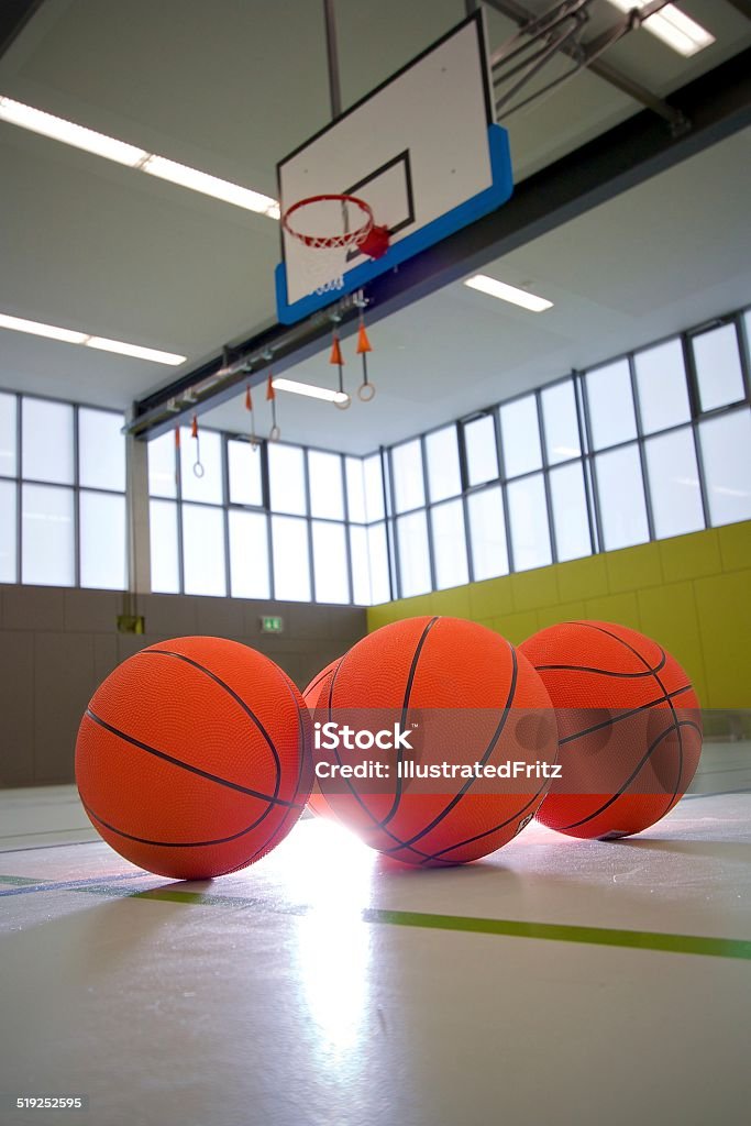 Basketballs in a sports hall Basketballs in front of the basket backlight Basketball - Sport Stock Photo