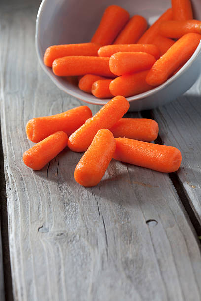 istock Cooked carrots in bowl on gray wooden table 519253175