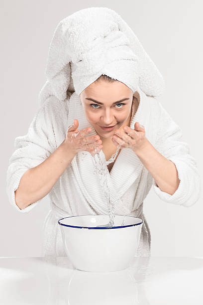 istock Young woman washing face with clean water 519262028