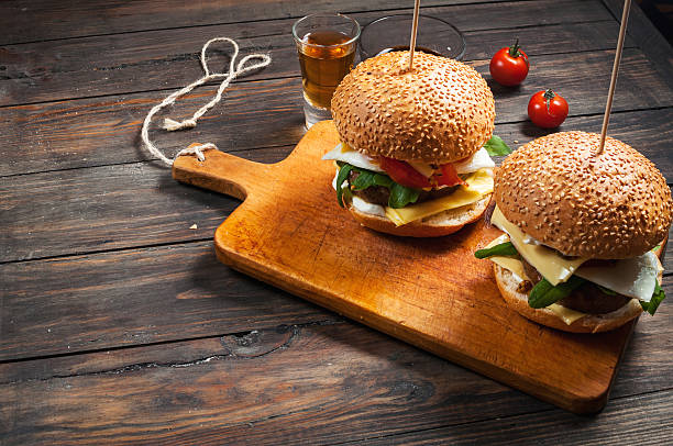 Fresh homemade burgers with whiskey Fresh homemade burgers with whiskey on wooden background. salt river photos stock pictures, royalty-free photos & images