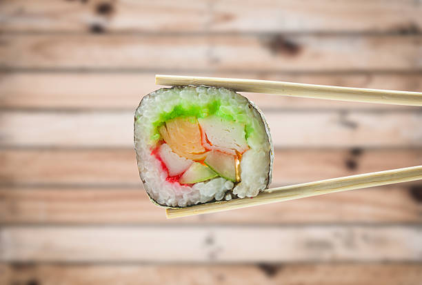 istock Sushi roll with chopsticks over wood background 519271030