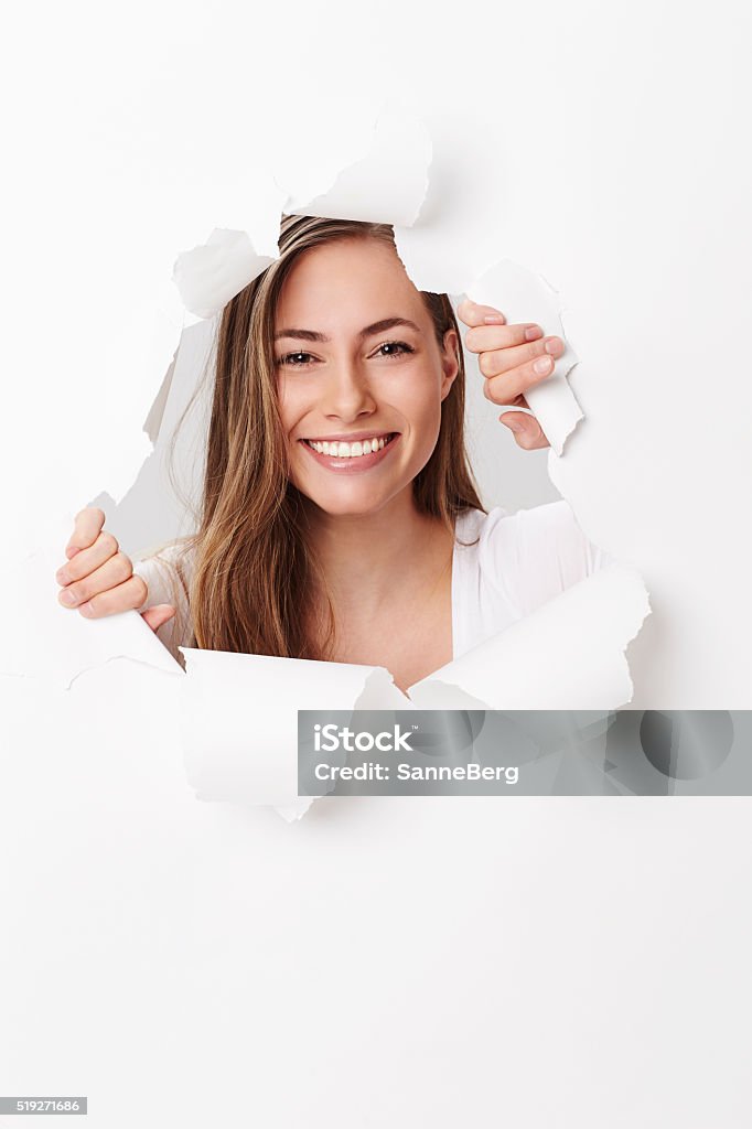 Young woman smiling through tears in paper, portrait 25-29 Years Stock Photo