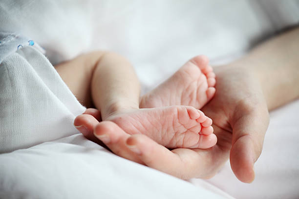 istock Baby's Feet in Mother Hand Closeup 519272156
