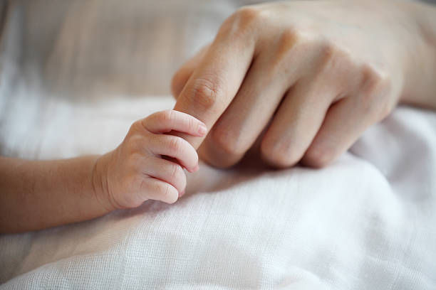 istock New Born Baby's Hand Gripping Mother Finger 519274376