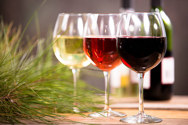 Wine, glasses on rustic outdoor dining table. Bottles. Nobody.
